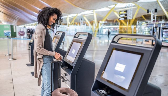 woman doing self-check-in at airport
